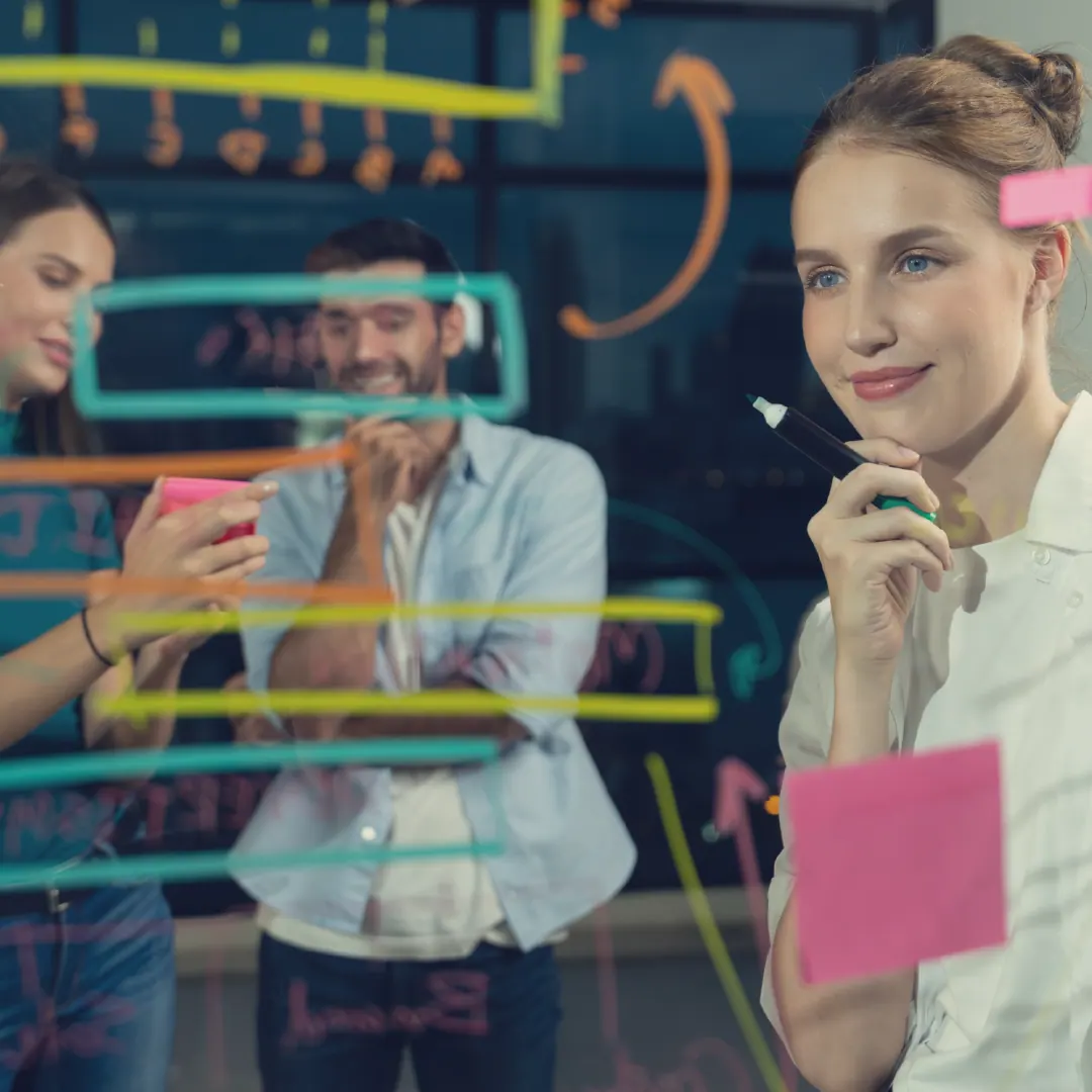 Strategie-Workshop – Team an einer Glastafel mit Haftnotizen